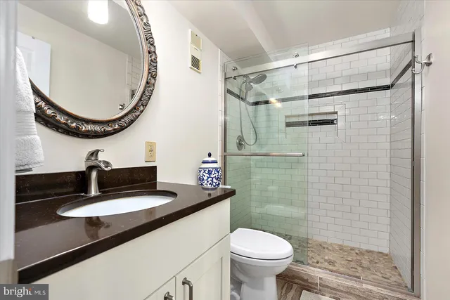 a bathroom with a sink a toilet and a mirror