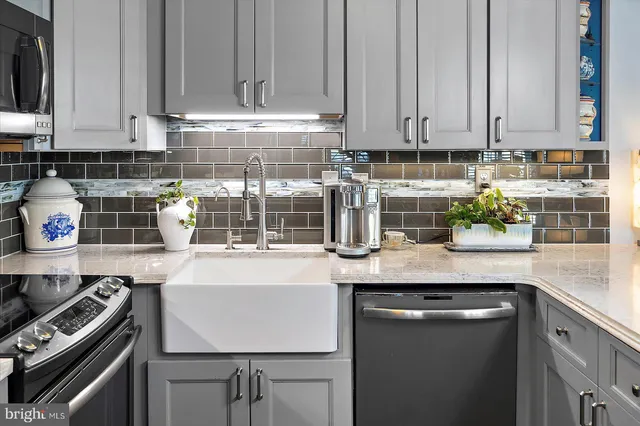 a kitchen with stainless steel appliances granite countertop a stove a sink and a white cabinets