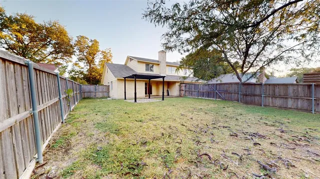a view of a yard with wooden fence and a large tree