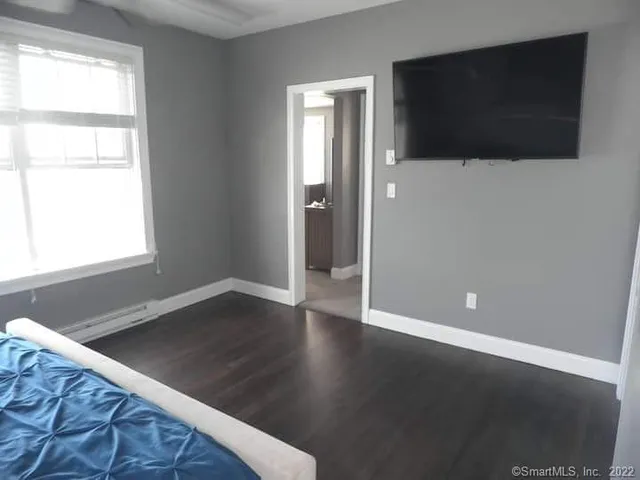 a view of a livingroom with wooden floor and a flat screen tv