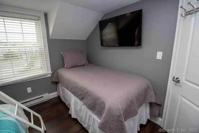 a bed room with a bed a flat screen tv and a window