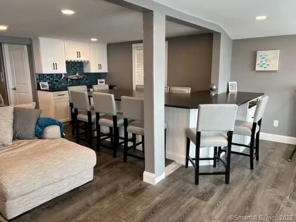 a kitchen with stainless steel appliances kitchen island granite countertop a table chairs and a refrigerator