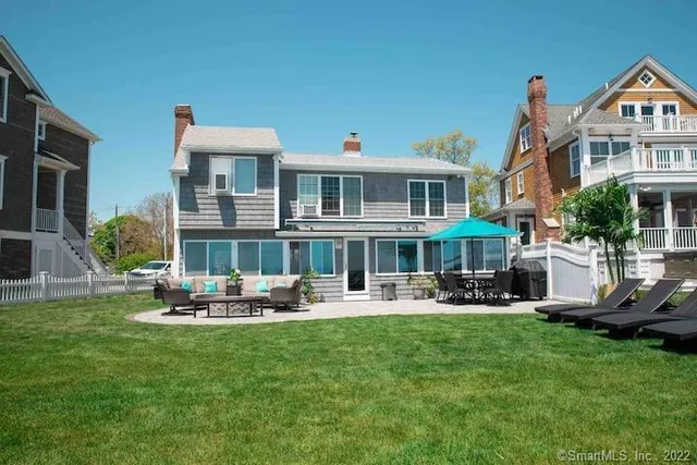 a front view of a house with garden and sitting area