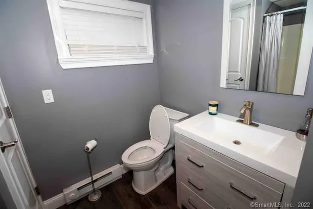 a bathroom with a toilet sink and mirror