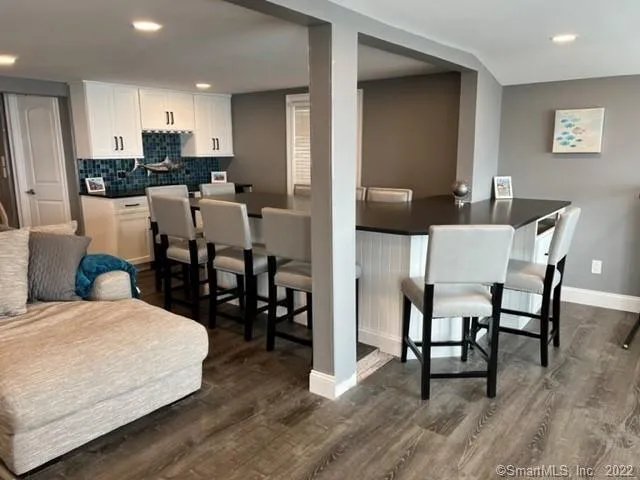 a kitchen with stainless steel appliances kitchen island granite countertop a table chairs and a refrigerator