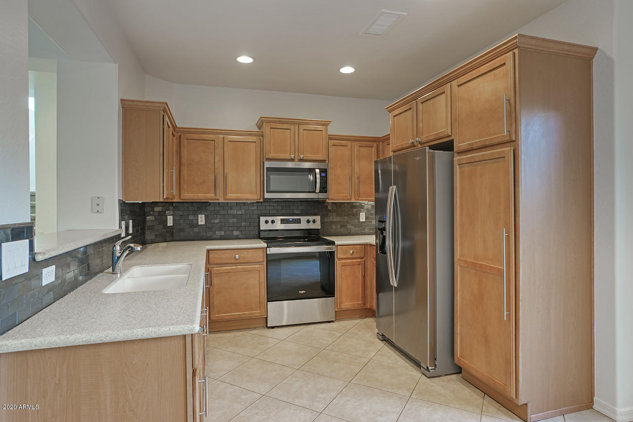 1958 West Davis Road Phoenix, AZ 85023 - Photo 7 of 25 a kitchen with stainless steel appliances granite countertop a refrigerator and a stove top oven