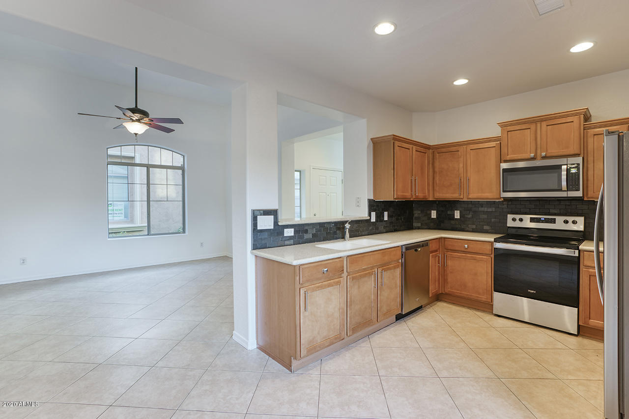 1958 West Davis Road Phoenix, AZ 85023 - Photo 8 of 25 a kitchen with stainless steel appliances granite countertop a stove top oven a sink a counter top space and cabinets