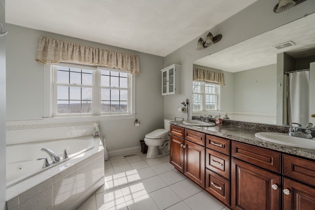 9 Kettle Way Dracut, MA 01826 - Photo 13 of 19 a spacious bathroom with a granite countertop double vanity sink a mirror and a bathtub