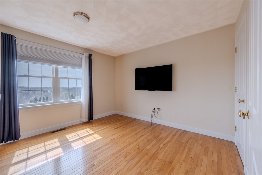 9 Kettle Way Dracut, MA 01826 - Photo 16 of 19 a view of a livingroom with an empty space & wooden floor and windows