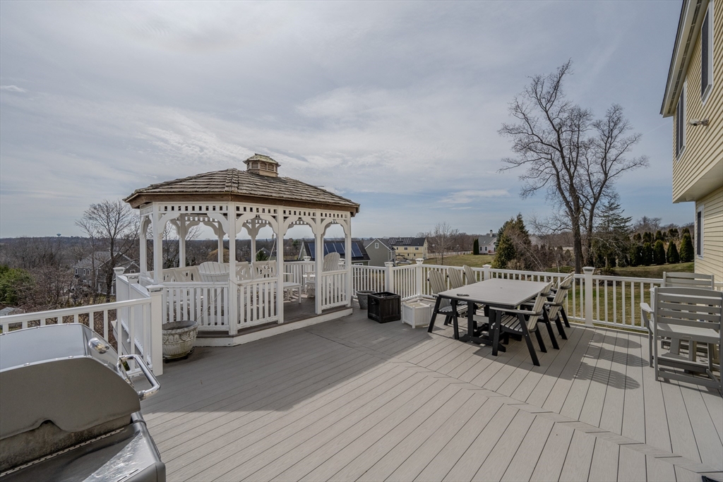 9 Kettle Way Dracut, MA 01826 - Photo 18 of 19 a view of a roof deck with table and chairs a barbeque with wooden floor and fence
