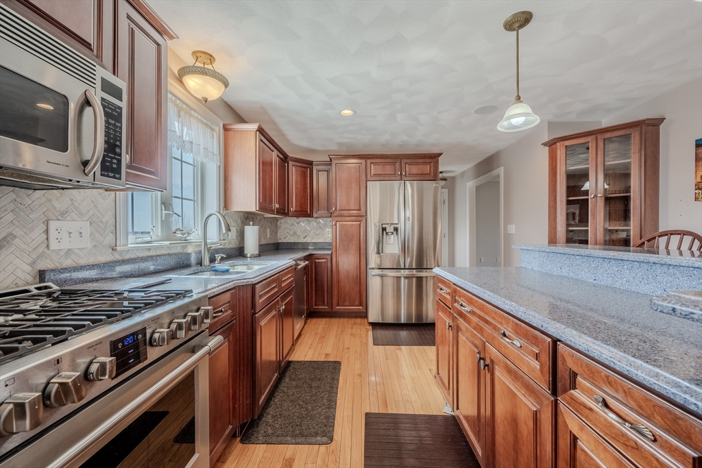 9 Kettle Way Dracut, MA 01826 - Photo 8 of 19 a kitchen with stainless steel appliances granite countertop a stove a sink dishwasher a refrigerator and a oven with wooden floor