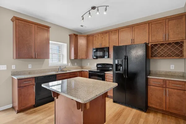 a kitchen with a sink a kitchen island a cabinetry and stainless steel appliances