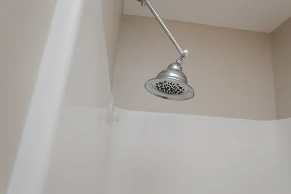 an empty room with chandelier fan and windows