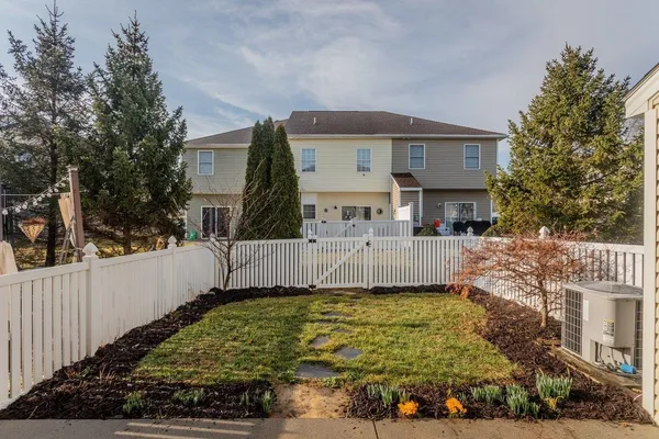 a view of a house with a small yard plants and large tree