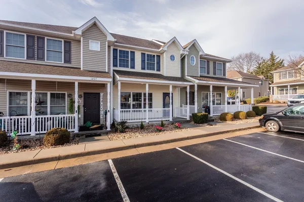 a view of a house with a small yard and wooden fence