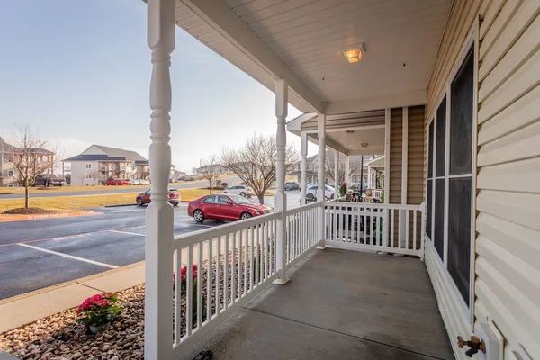 a front view of house with yard and trees in the background