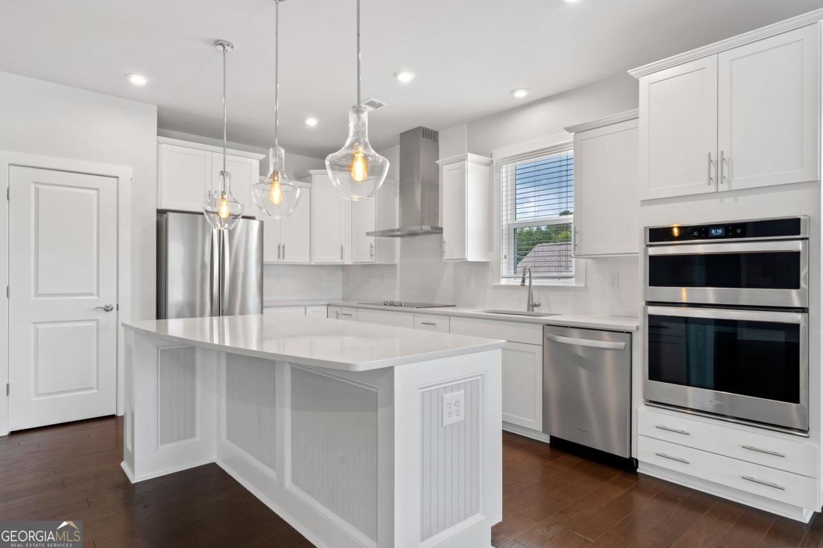 1061 Little Shls Road Greensboro, GA 30642 - Photo 15 of 41 a kitchen with stainless steel appliances granite countertop a sink a stove a refrigerator and island with wooden floor