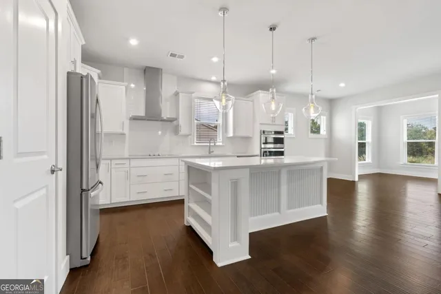 a kitchen with stainless steel appliances a refrigerator and wooden floor