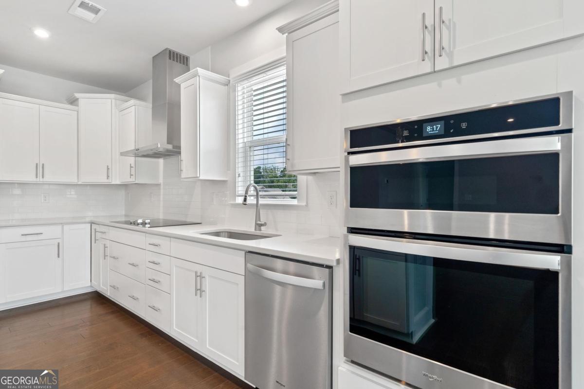 1061 Little Shls Road Greensboro, GA 30642 - Photo 18 of 41 a kitchen with stainless steel appliances white cabinets and a sink