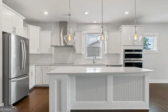 a kitchen with stainless steel appliances granite countertop a refrigerator a sink and a stove