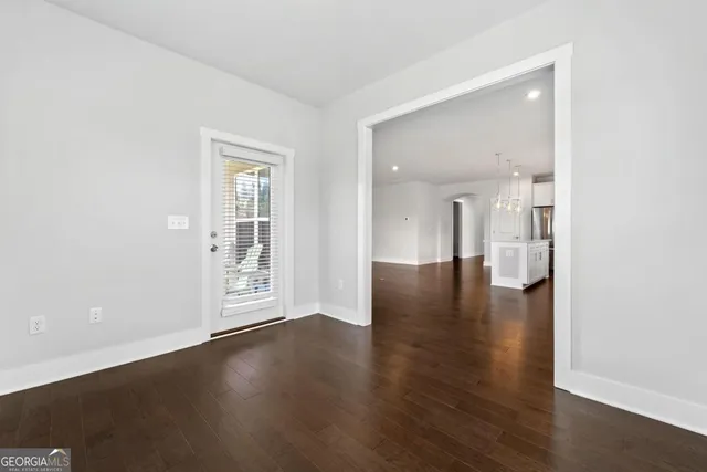 an empty room with wooden floor and a bathroom