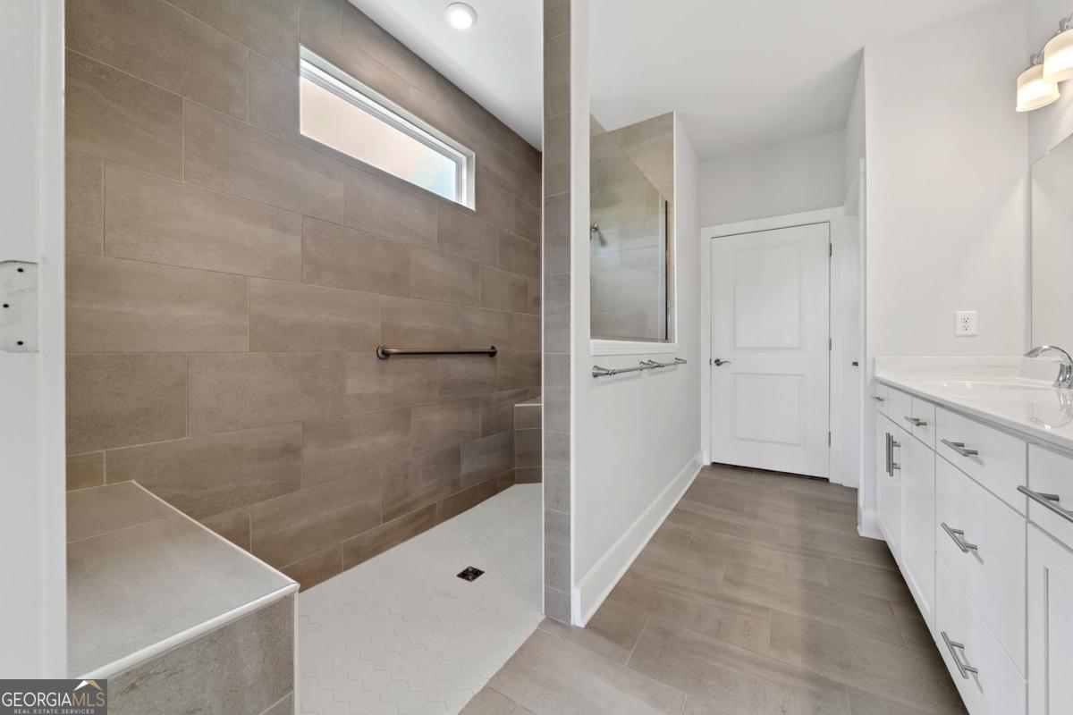 1061 Little Shls Road Greensboro, GA 30642 - Photo 26 of 41 a bathroom with a granite countertop shower a sink and a mirror