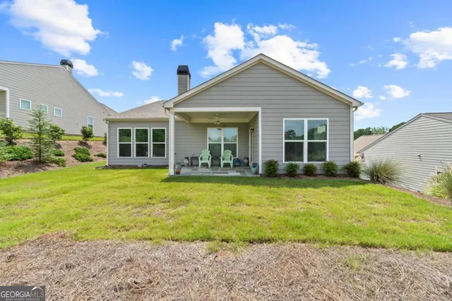 a view of a house with backyard and sitting area