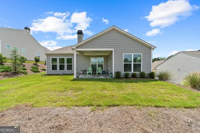 a view of a house with backyard and sitting area