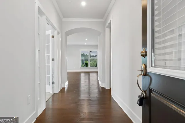 a view of a hallway with wooden floor and windows