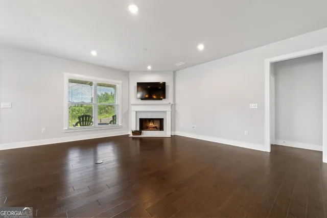 an empty room with wooden floor and a window
