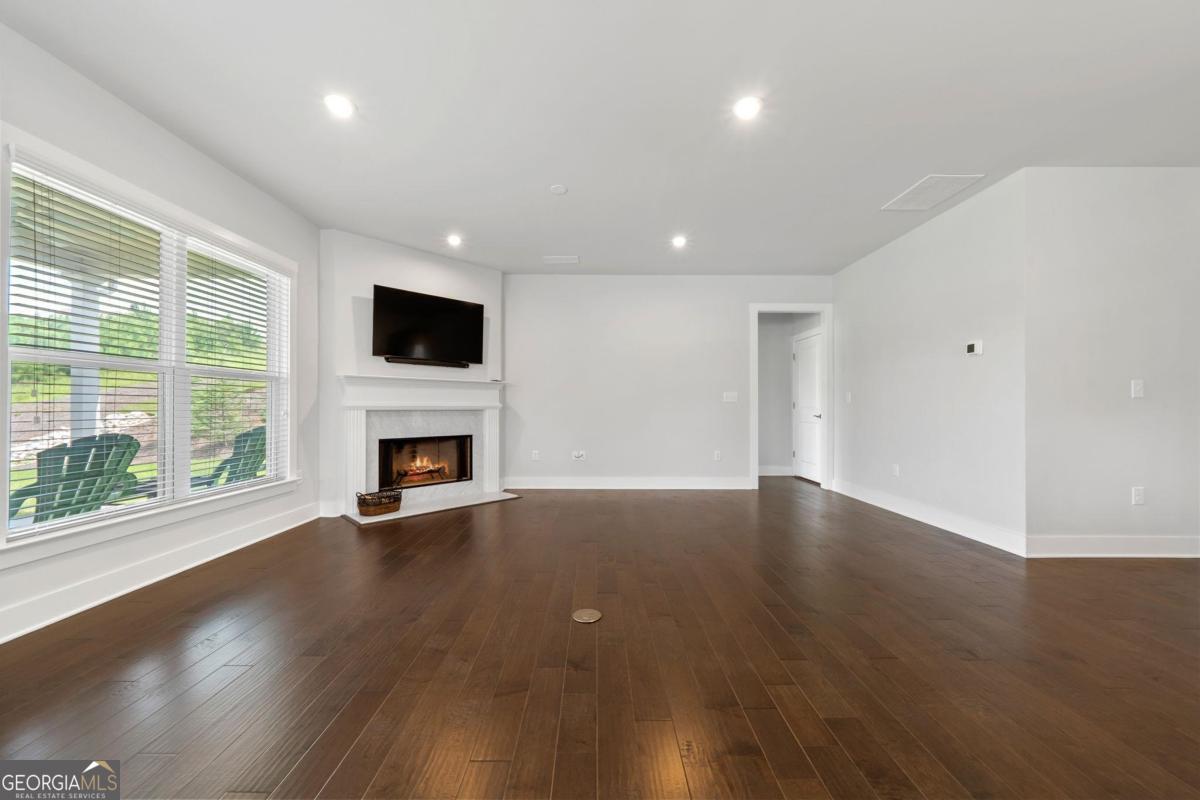 1061 Little Shls Road Greensboro, GA 30642 - Photo 9 of 41 a view of empty room with wooden floor and fireplace