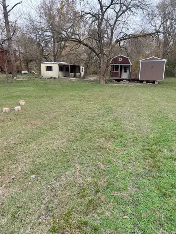 a front view of a house with a garden and trees