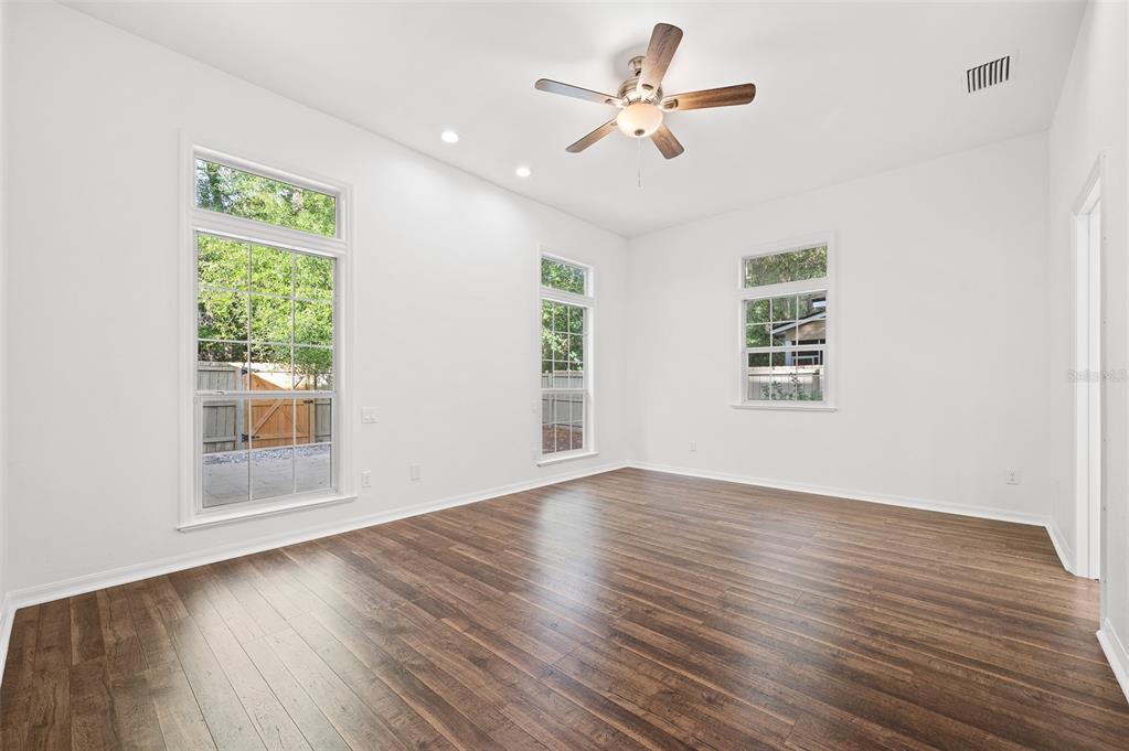 9702 Southwest 35th Lane Gainesville, FL 32608 - Photo 19 of 46 a view of an empty room with wooden floor and a window