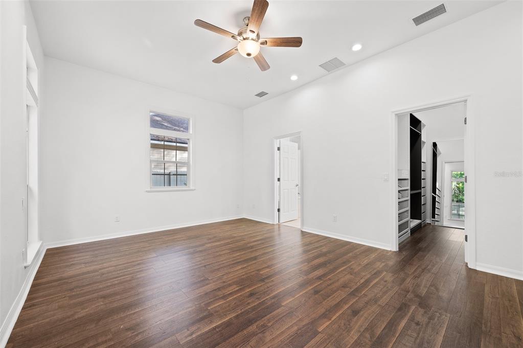 9702 Southwest 35th Lane Gainesville, FL 32608 - Photo 21 of 46 a view of an empty room with wooden floor and a ceiling fan