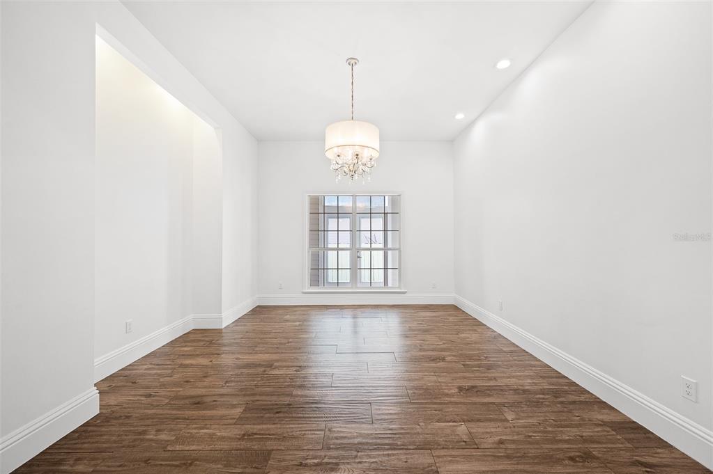 9702 Southwest 35th Lane Gainesville, FL 32608 - Photo 7 of 46 a view of an empty room with wooden floor and windows