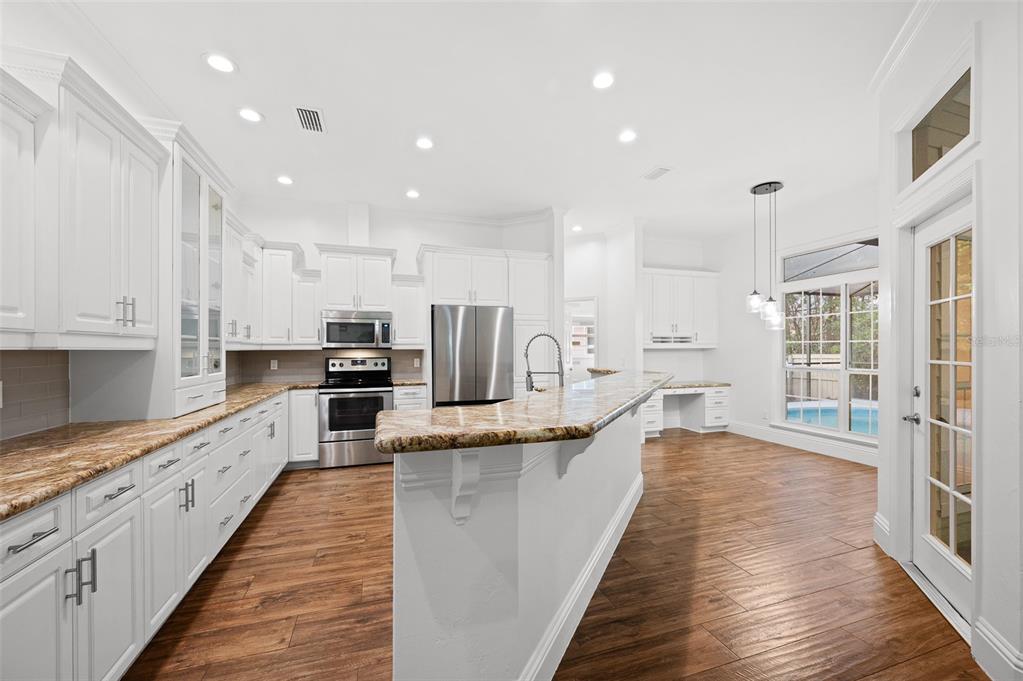 9702 Southwest 35th Lane Gainesville, FL 32608 - Photo 9 of 46 a large kitchen with stainless steel appliances lots of counter space and wooden floor