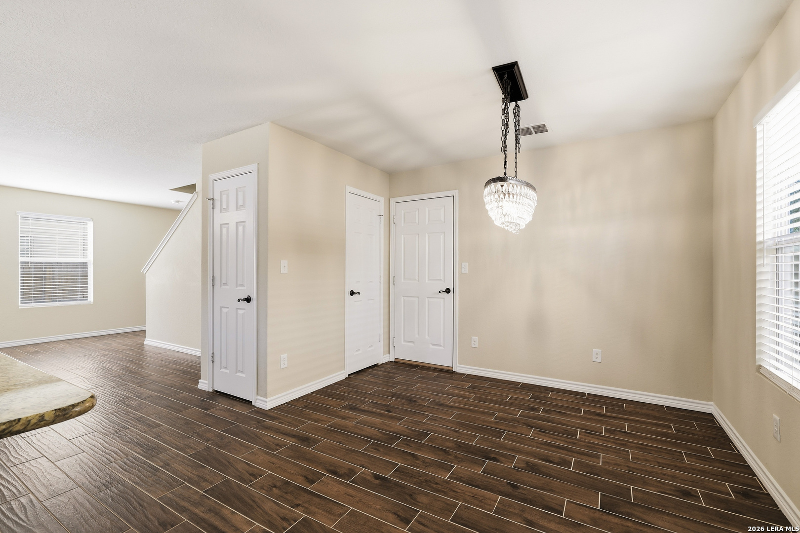 11839 Dove Ranch San Antonio, TX 78254 - Photo 12 of 35 an empty room with wooden floor cabinet and windows