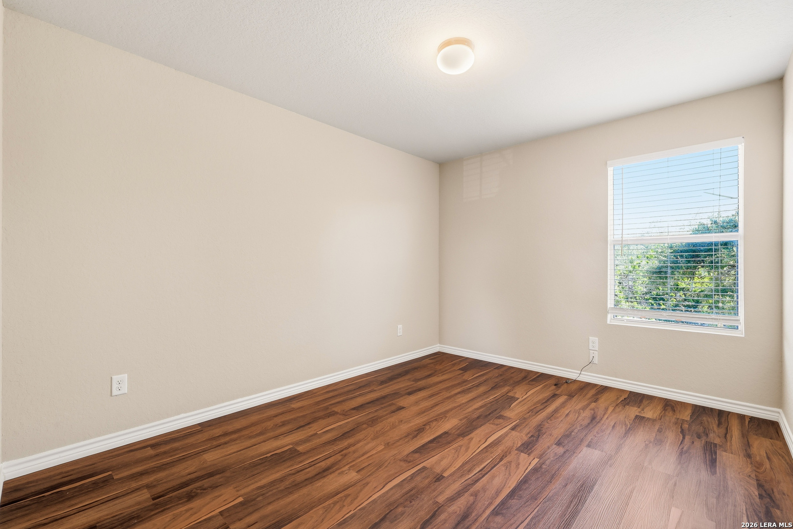 11839 Dove Ranch San Antonio, TX 78254 - Photo 19 of 35 an empty room with wooden floor and windows