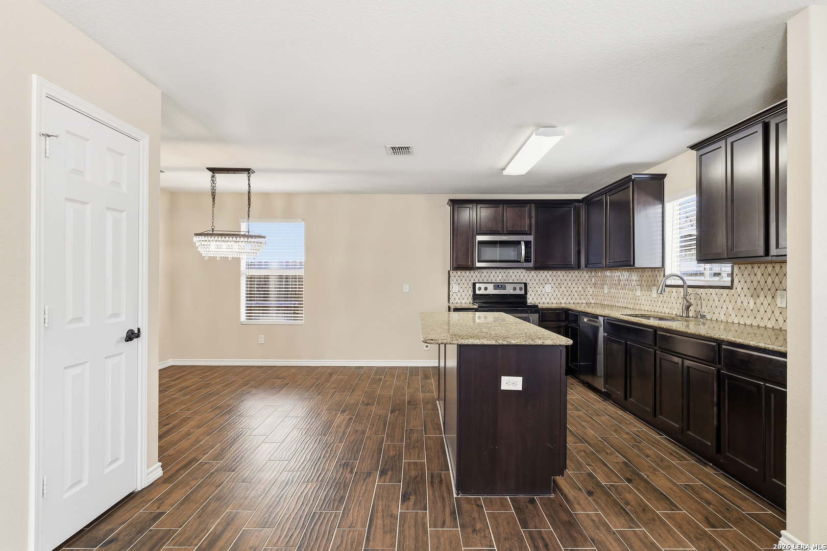 11839 Dove Ranch San Antonio, TX 78254 - Photo 9 of 35 a kitchen with stainless steel appliances granite countertop a stove a sink dishwasher and a refrigerator with wooden floor