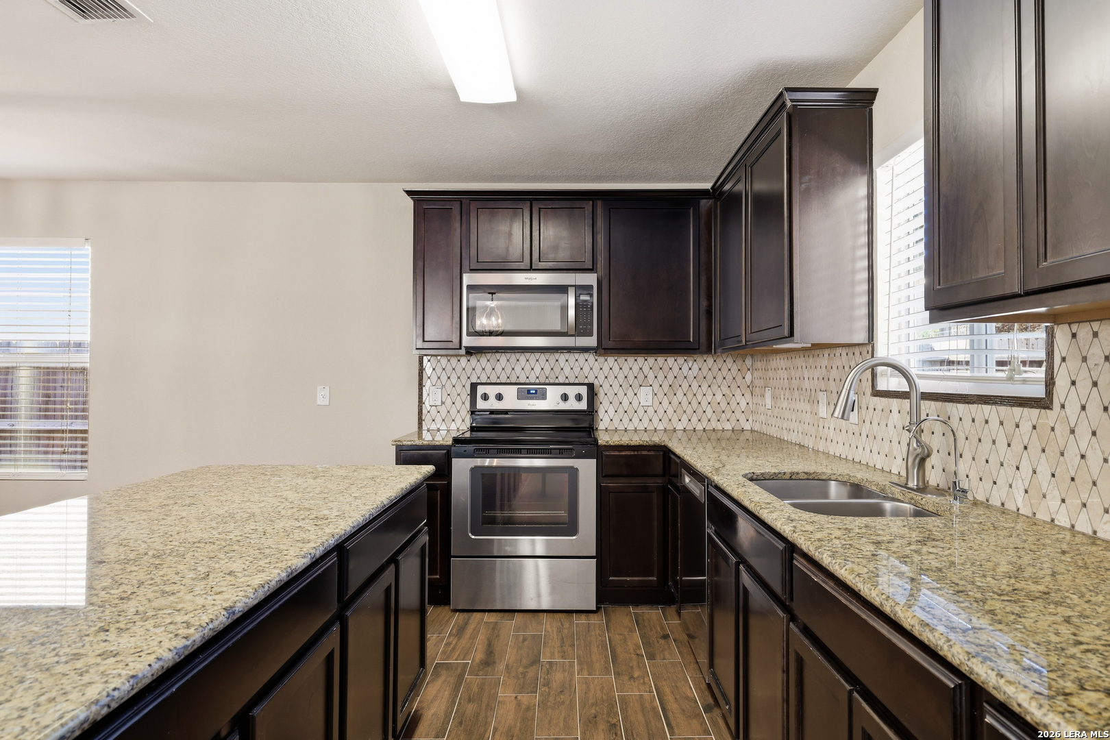 11839 Dove Ranch San Antonio, TX 78254 - Photo 10 of 35 a kitchen with granite countertop stainless steel appliances and wooden cabinets