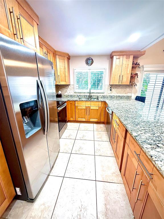 3117 Kingswood Terrace, Unit 3117 Boca Raton, FL 33431 - Photo 9 of 15 a large kitchen with granite countertop a sink a stove a washer dryer and next to a window