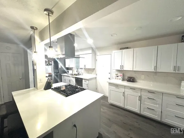 a kitchen with kitchen island granite countertop a sink cabinets and stainless steel appliances