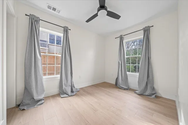 an empty room with windows and closet