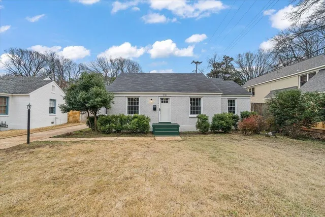 a view of a house with a yard and potted plants