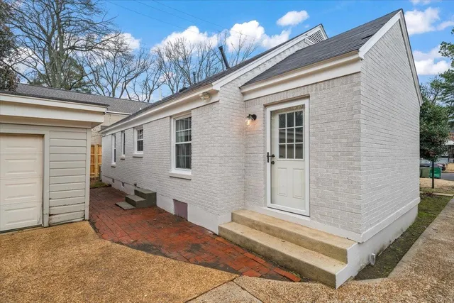 a tall building with couple of cars parked in front of it