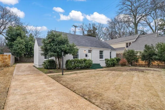 a view of a house with a yard and potted plants