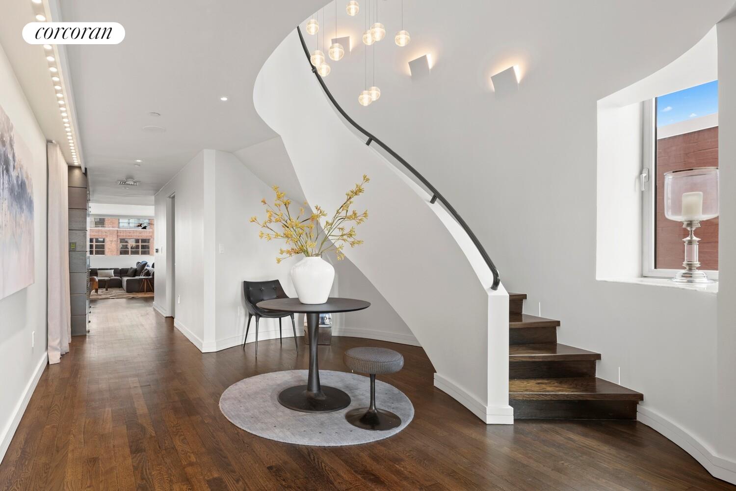 a view of entryway and hall with wooden floor