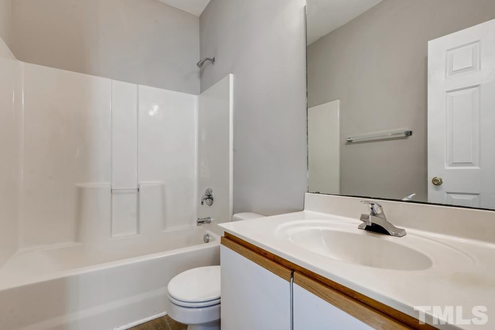 2336 Milburnie Road Raleigh, NC 27610 - Photo 16 of 28 a bathroom with a sink a toilet and a large mirror