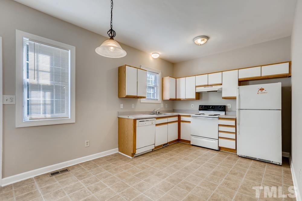 2336 Milburnie Road Raleigh, NC 27610 - Photo 8 of 28 a kitchen with white cabinets and white appliances