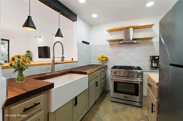 a kitchen with stainless steel appliances a sink a stove and cabinets